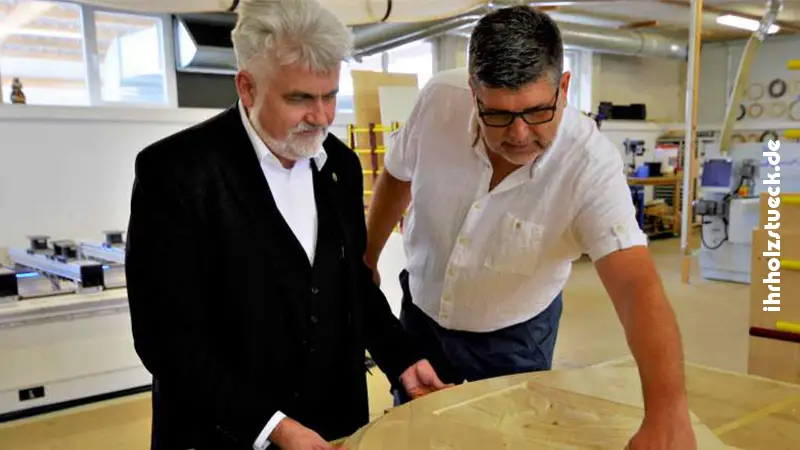 Minister Willingmann (links) lässt sich die Moeglichkeiten der Holzbearbeitung und die Arbeitsweise der neu angeschafften Maschine beschreiben. FOTO: DIETMAR BEBBER